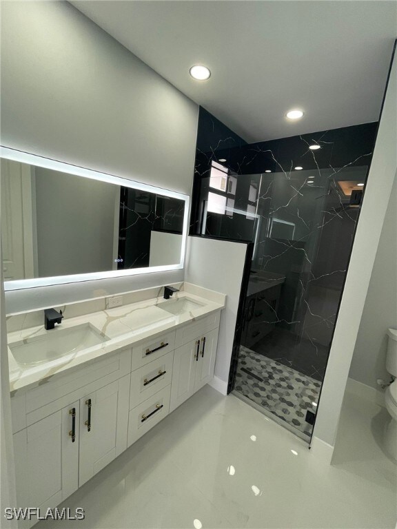 2710 10th St SW, Lehigh Acres, FL 33976 - bathroom with toilet, a marble finish shower, double vanity, and recessed lighting