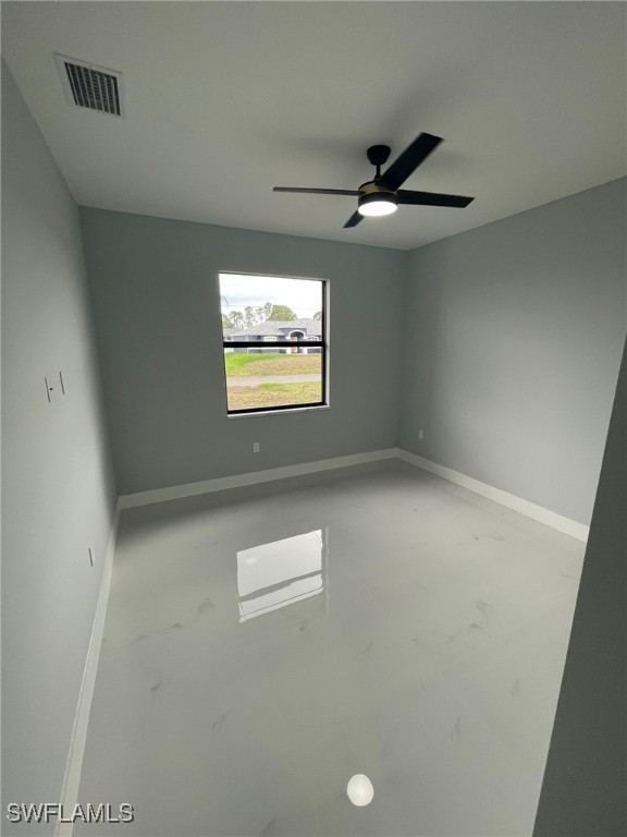 2710 10th St SW, Lehigh Acres, FL 33976 - unfurnished room featuring baseboards, finished concrete floors, and a ceiling fan