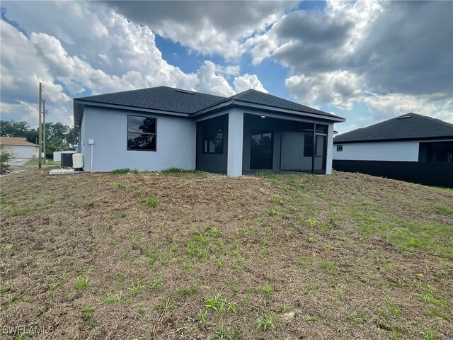 2710 10th St SW, Lehigh Acres, FL 33976 - rear view of house featuring central AC unit, a sunroom, and stucco siding