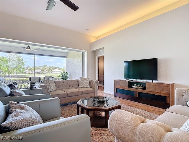 living room featuring a ceiling fan, vaulted ceiling, and wood finished floors