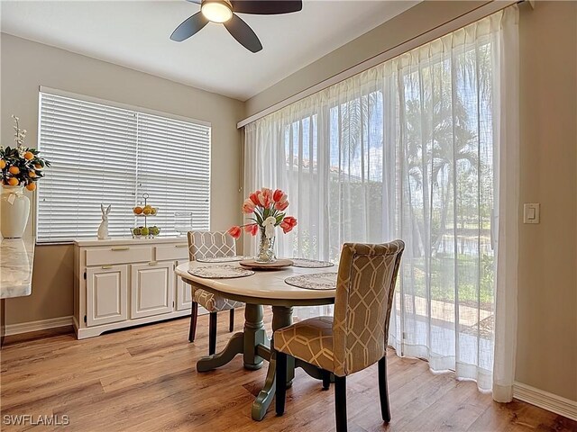 dining room with light wood-style floors, a ceiling fan, and baseboards