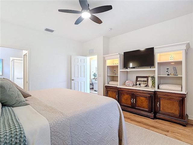 bedroom with visible vents, ceiling fan, light wood-style floors, and ensuite bathroom
