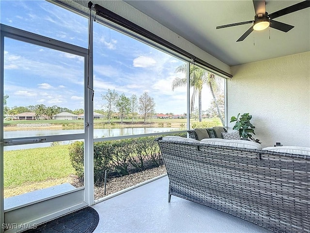 sunroom / solarium featuring ceiling fan and a water view