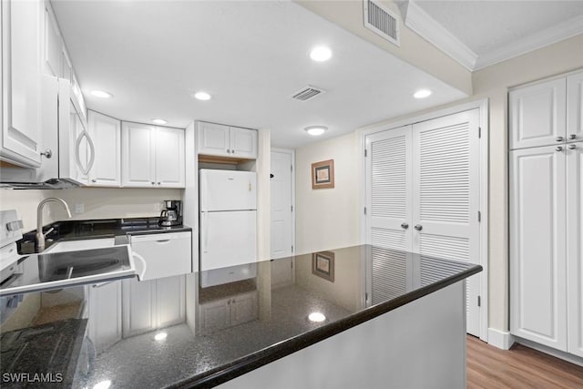 2230 Camino Del Mar Dr Unit 1C4, Sanibel, FL 33957 - kitchen with white cabinets, freestanding refrigerator, visible vents, and crown molding