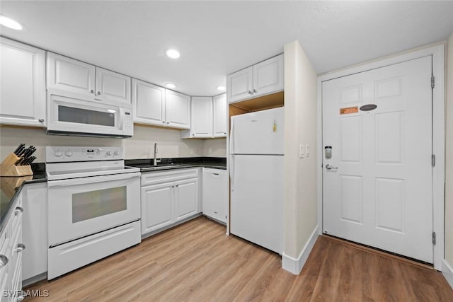 2230 Camino Del Mar Dr Unit 1C4, Sanibel, FL 33957 - kitchen with dark countertops, white cabinetry, a sink, and white appliances