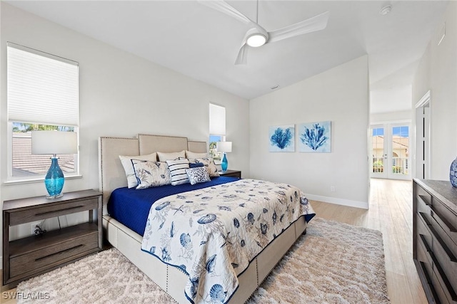bedroom featuring wood finished floors, vaulted ceiling, baseboards, and ceiling fan