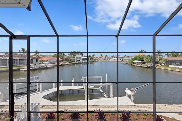 dock area with a water view, boat lift, and a residential view