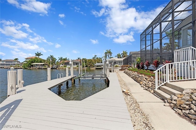 dock with a water view, boat lift, and a lanai