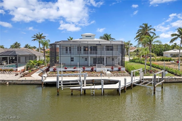 back of house featuring a water view, a lanai, boat lift, and a patio area