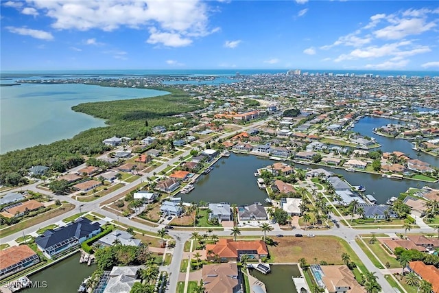 aerial view of property's location featuring a large body of water and nearby suburban area