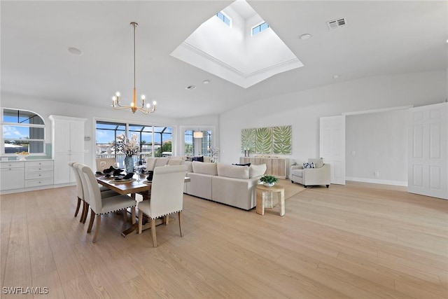 dining area featuring light wood-type flooring, a chandelier, and a skylight