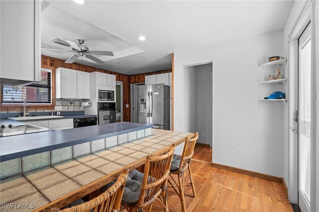 210 Miramar St, Fort Myers Beach, FL 33931 - kitchen featuring white cabinetry, light wood-type flooring, appliances with stainless steel finishes, and plenty of natural light