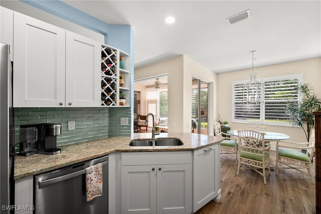 770 Tarpon Cove Dr Unit 702, Naples, FL 34110 - kitchen with stainless steel dishwasher, dark wood-style flooring, plenty of natural light, a peninsula, and recessed lighting