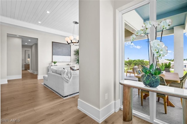 201 8th St S Unit 301, Naples, FL 34102 - hallway with an inviting chandelier, baseboards, light wood finished floors, and recessed lighting