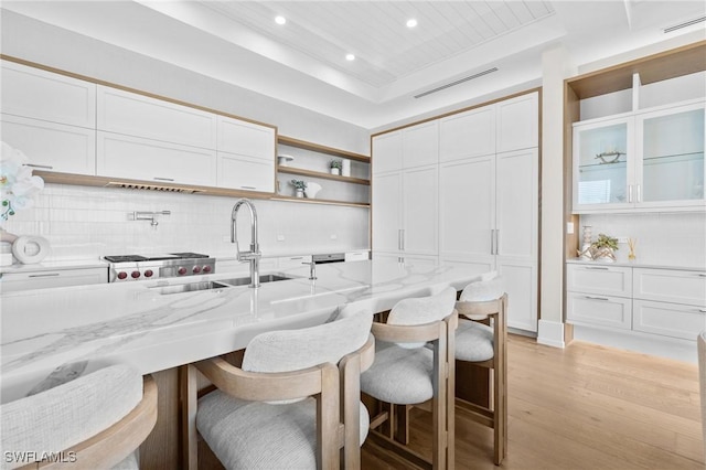 201 8th St S Unit 301, Naples, FL 34102 - kitchen featuring a tray ceiling, a breakfast bar area, visible vents, and white cabinets