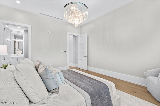 201 8th St S Unit 301, Naples, FL 34102 - bedroom with baseboards, an inviting chandelier, recessed lighting, and wood finished floors