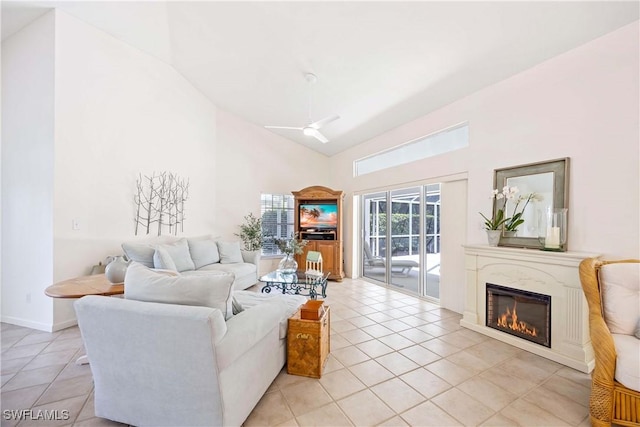 597 Lambton Ln, Naples, FL 34104 - living area with high vaulted ceiling, a ceiling fan, light tile patterned flooring, a glass covered fireplace, and baseboards