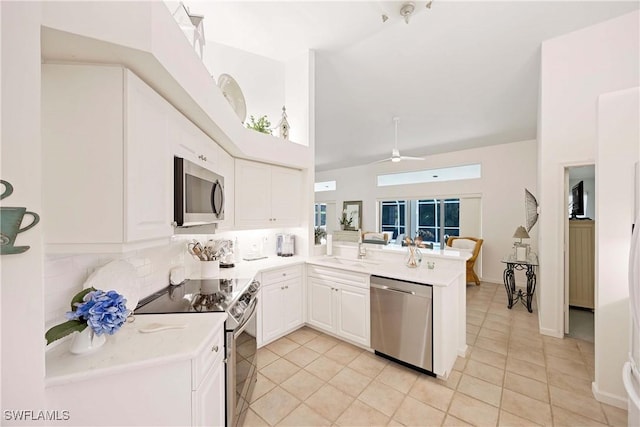 597 Lambton Ln, Naples, FL 34104 - kitchen with a peninsula, white cabinetry, appliances with stainless steel finishes, and light tile patterned flooring