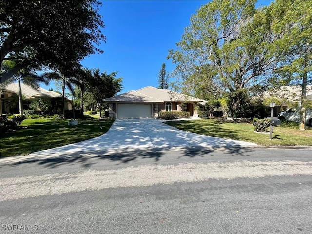view of front of home featuring concrete driveway, a front yard, and a garage