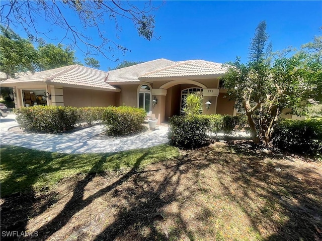 view of front of property with a tile roof and stucco siding