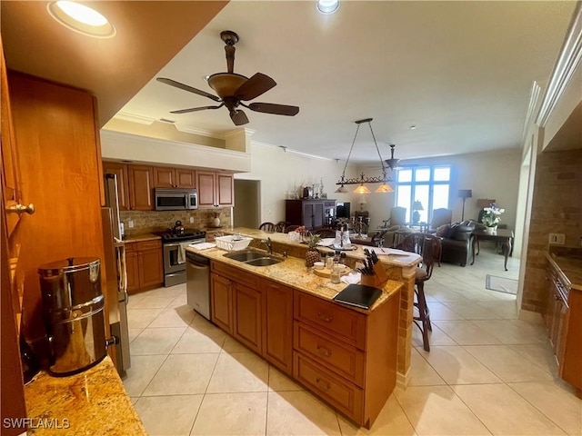kitchen featuring a ceiling fan, a sink, open floor plan, light tile patterned floors, and stainless steel appliances