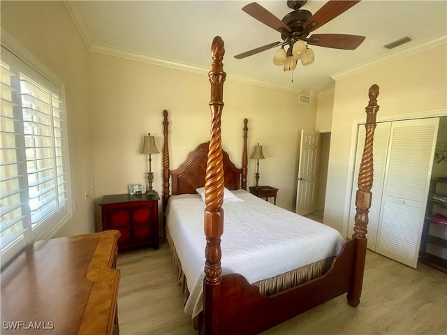 bedroom with visible vents, ornamental molding, a closet, light wood-style flooring, and ceiling fan