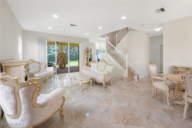 living area with visible vents, marble finish floor, and stairs