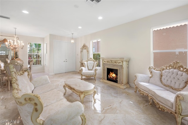 living room featuring recessed lighting, marble finish floor, an inviting chandelier, a high end fireplace, and visible vents
