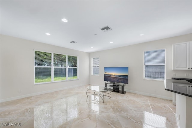 living room with baseboards, visible vents, and recessed lighting