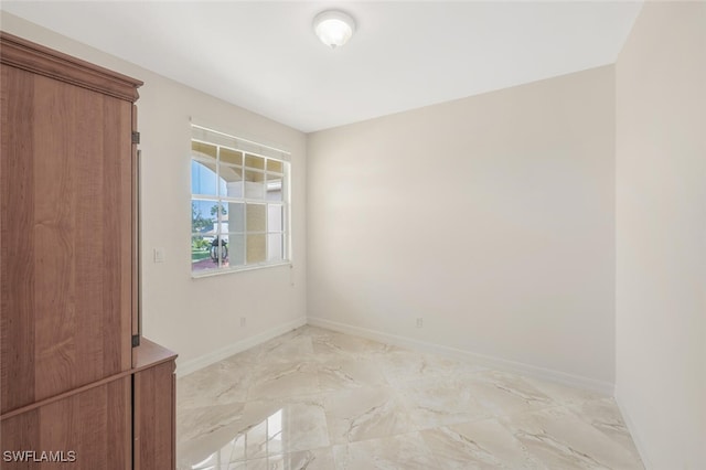 empty room with baseboards and marble finish floor