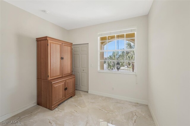 interior space featuring marble finish floor and baseboards