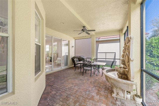 sunroom / solarium featuring ceiling fan and outdoor dining space
