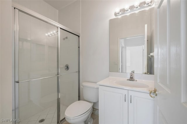 bathroom with vanity, a shower stall, and toilet
