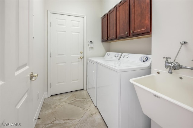 washroom featuring a sink, separate washer and dryer, marble finish floor, cabinet space, and baseboards