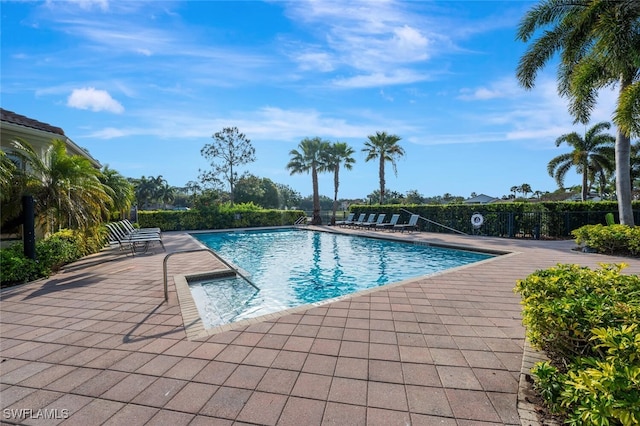 pool with a patio and fence