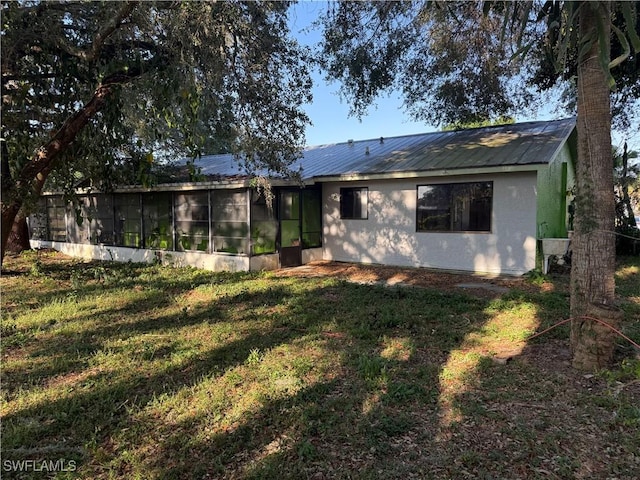 4004 Sena Ln, Labelle, FL 33935 - back of house featuring a lawn, a sunroom, and metal roof