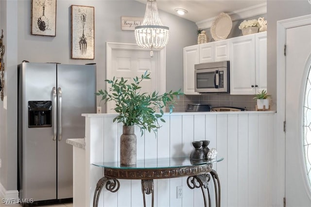 2748 45th Ave NE, Naples, FL 34120 - kitchen featuring decorative backsplash, white cabinets, appliances with stainless steel finishes, light countertops, and an inviting chandelier