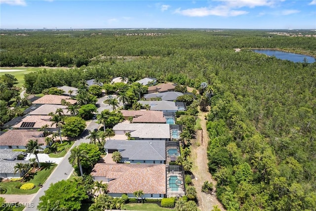 drone / aerial view featuring a water view, a view of trees, and a residential view