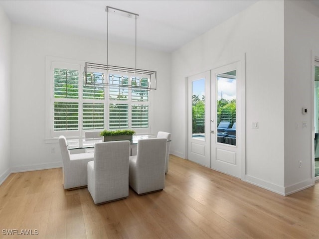 201 S Heathwood Dr, Marco Island, FL 34145 - dining space with baseboards, a healthy amount of sunlight, french doors, and light wood-style flooring