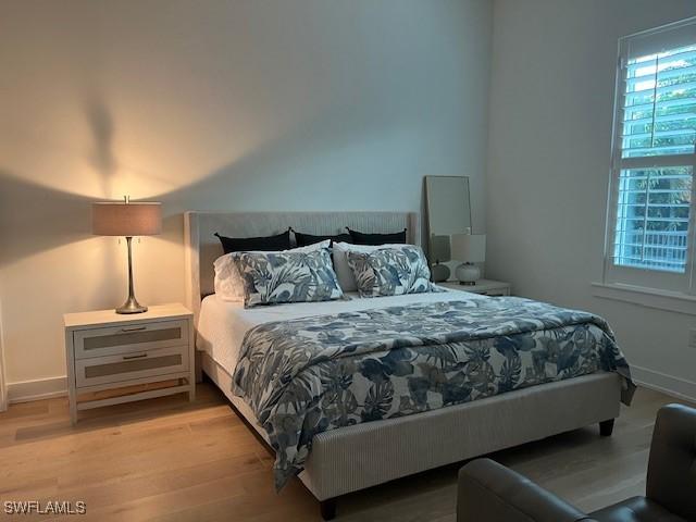 201 S Heathwood Dr, Marco Island, FL 34145 - bedroom with baseboards and wood finished floors