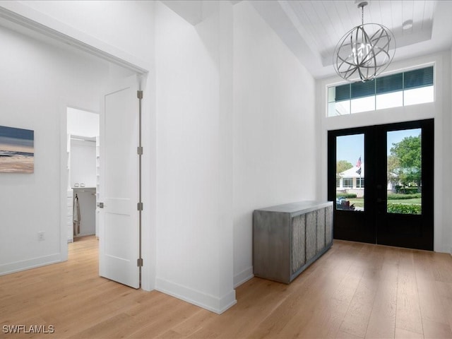 201 S Heathwood Dr, Marco Island, FL 34145 - foyer featuring a chandelier, light wood finished floors, baseboards, and french doors