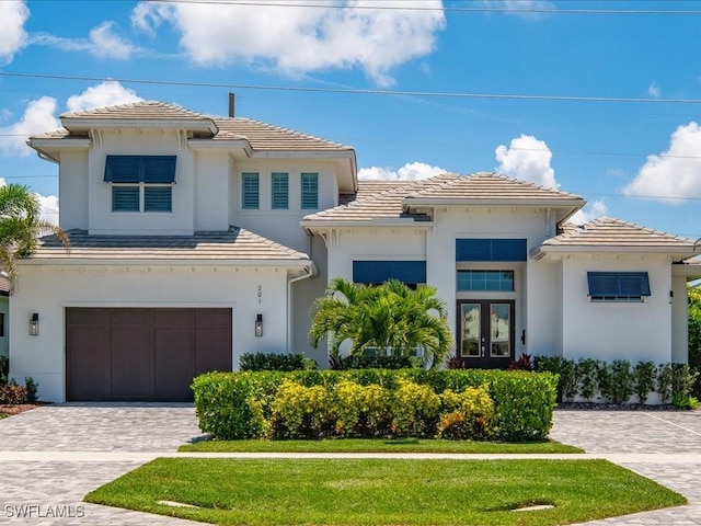201 S Heathwood Dr, Marco Island, FL 34145 - view of front of home with french doors, a tiled roof, a garage, stucco siding, and decorative driveway