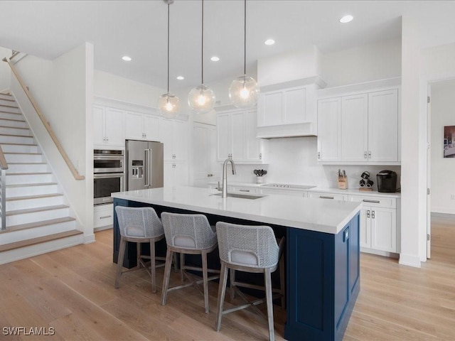 201 S Heathwood Dr, Marco Island, FL 34145 - kitchen featuring white cabinets, light wood-style flooring, stainless steel appliances, and a sink
