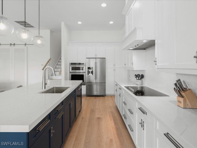 201 S Heathwood Dr, Marco Island, FL 34145 - kitchen with light wood-style flooring, a sink, white cabinetry, decorative light fixtures, and appliances with stainless steel finishes
