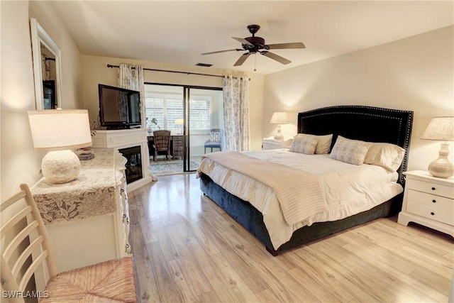 bedroom featuring ceiling fan, access to exterior, visible vents, and light wood-type flooring