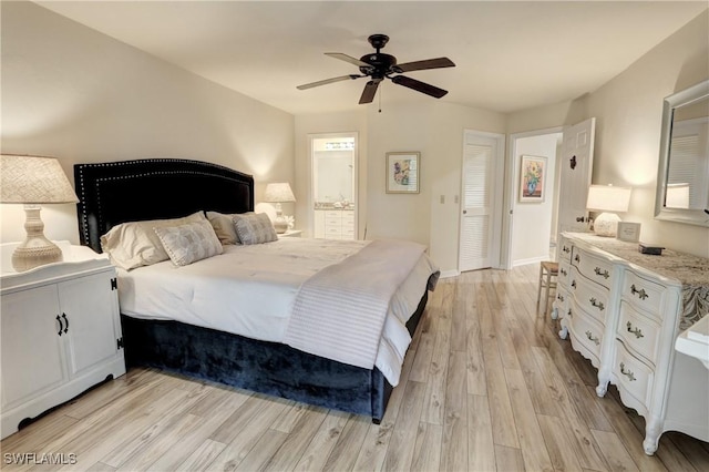 bedroom featuring light wood-type flooring, ensuite bathroom, baseboards, and ceiling fan