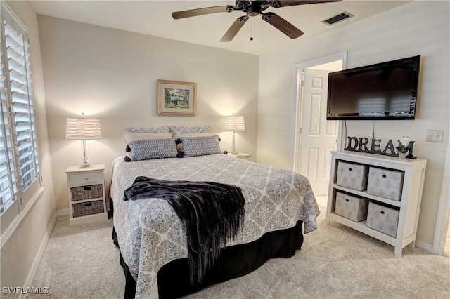 bedroom featuring light carpet, baseboards, visible vents, and multiple windows
