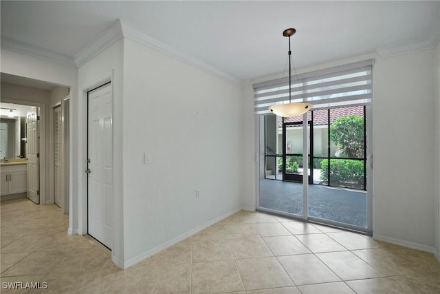 spare room with baseboards, ornamental molding, and light tile patterned flooring