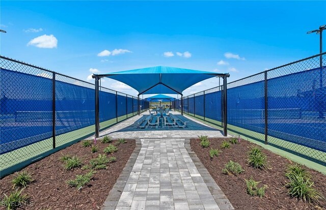 view of community with fence and a tennis court