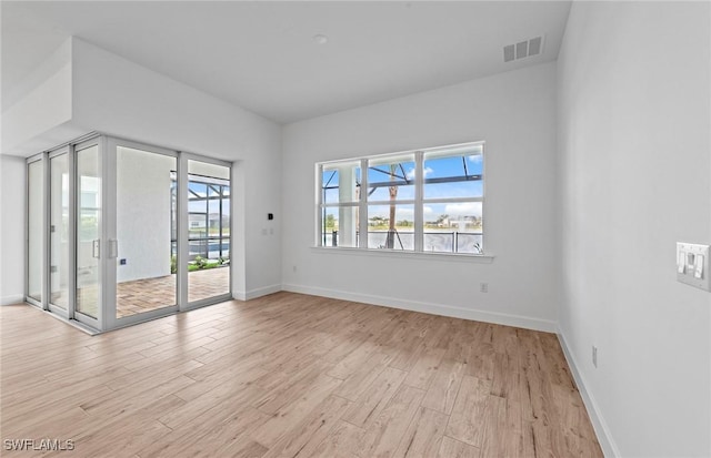 unfurnished room with baseboards and light wood-style flooring